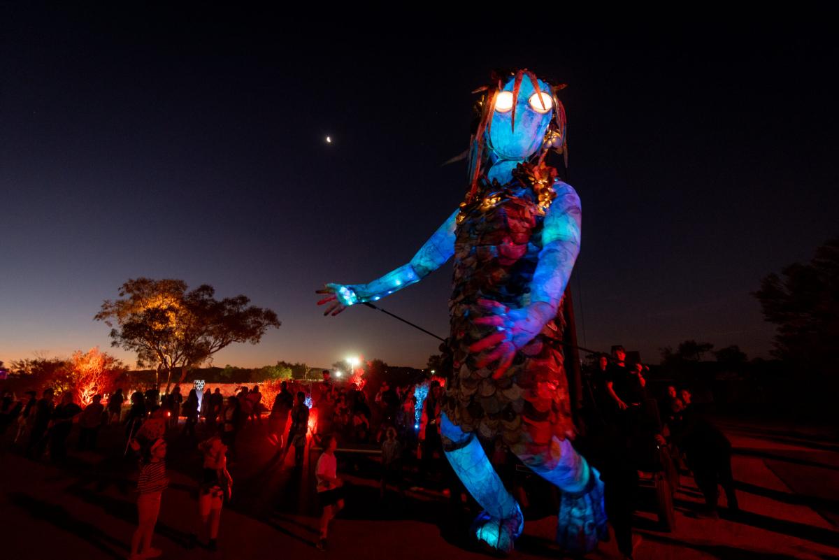 Parrtjima 2024. Arelhe Urrperle walks through the crowds