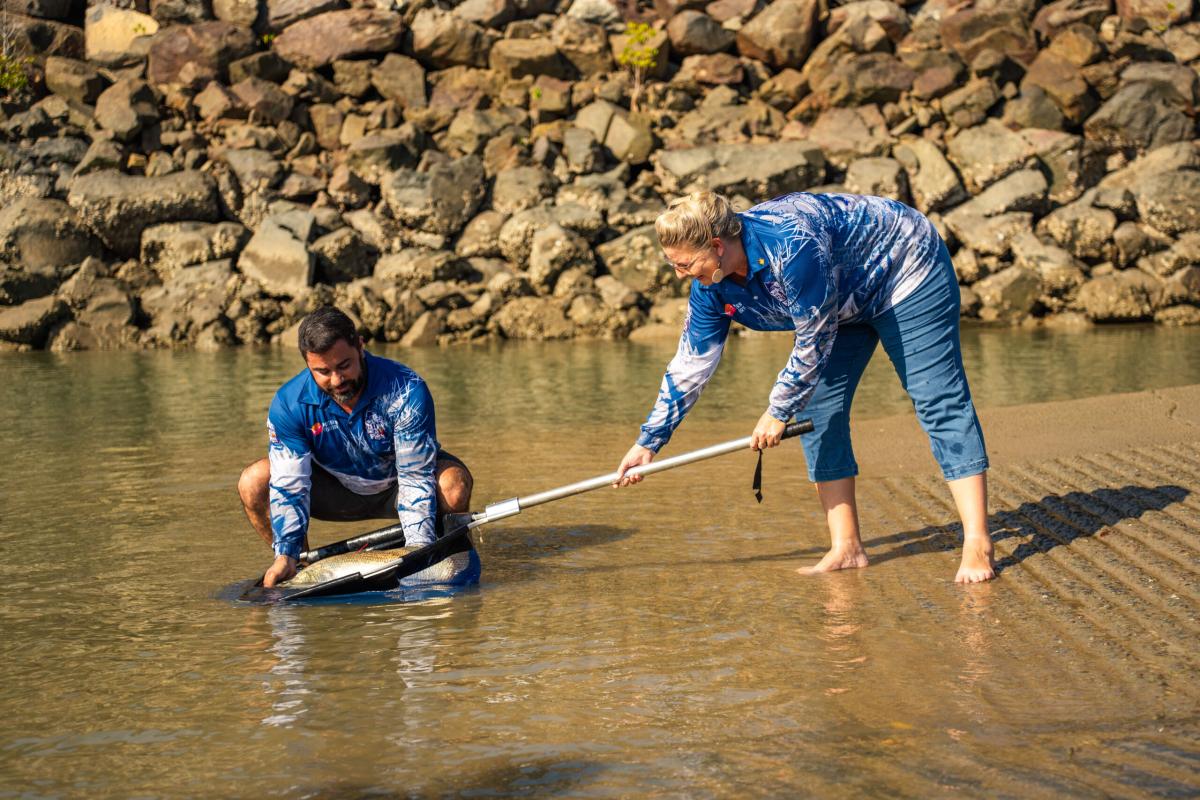 Sportsbet's Thijs Bors and Minister for Major Events Marie-Clare Boothby release a red-tagged barra