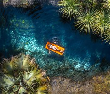 A woman floats on a inflatable bed in Bitter Springs, Elsey National Park