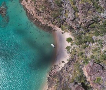 aerial image of ocean and land with one boat