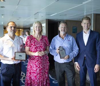 image of captain with others at plaque presentation