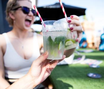 Woman with a drink and a hand with a drink in forefront