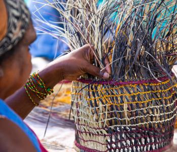 An Aboriginal woman weaves a basket for demonstration in Katherine