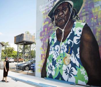 woman looking up at mural of woman in katherine