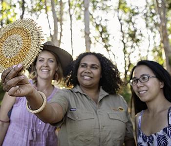 Tourists and tour guide looking at handmade crafts