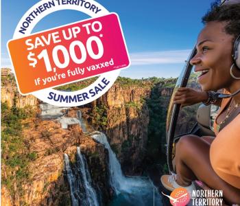 Image of woman looking out from helicopter over a waterfall with a logo in left hand corner