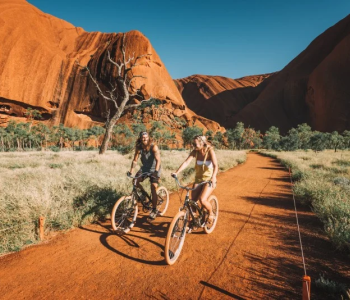 Two bikes riding across Uluru