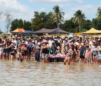 People rowing in a raft made of beer cans