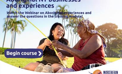 Aboriginal lady teaching basket weaving to a smiling tourist