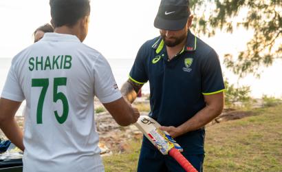 A Cricket player signs a fan's bat